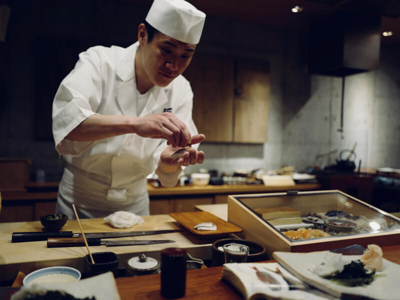 Chef making sushi in professional kitchen